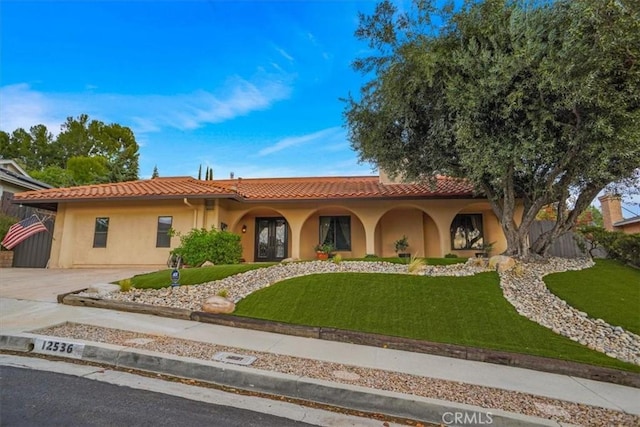 mediterranean / spanish-style house with a front yard