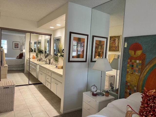 bathroom with a textured ceiling, vanity, and tile patterned floors