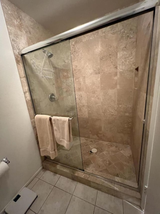 bathroom featuring tile patterned flooring and a shower with shower door