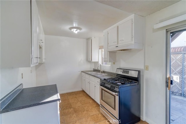 kitchen featuring under cabinet range hood, a sink, white cabinetry, gas stove, and baseboards