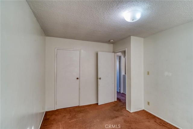 unfurnished bedroom featuring carpet and a textured ceiling