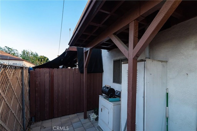 view of patio with washer / clothes dryer and fence