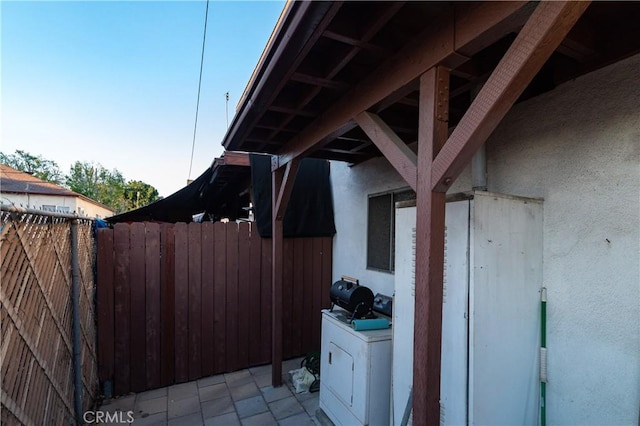 view of home's exterior featuring washer / clothes dryer, stucco siding, and fence