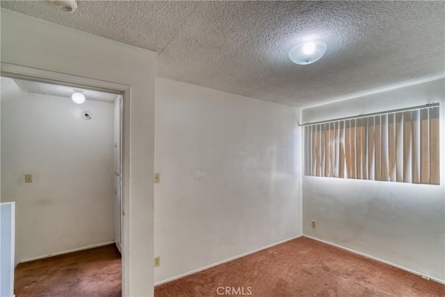 carpeted spare room with a textured ceiling