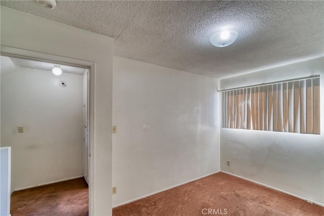 carpeted empty room featuring a textured ceiling