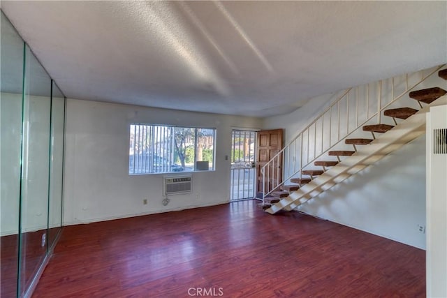 interior space with stairway, wood finished floors, and a wall mounted air conditioner