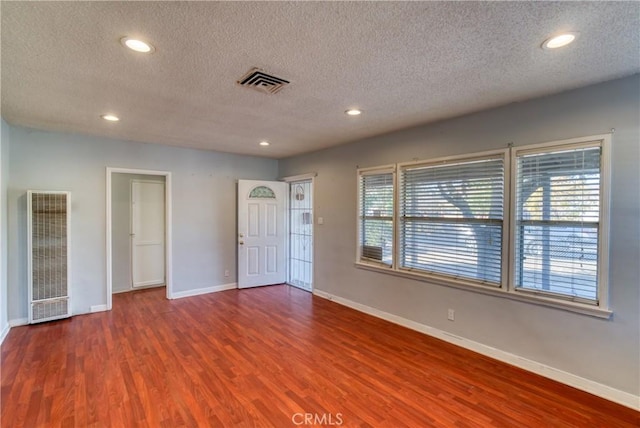 interior space with a textured ceiling and hardwood / wood-style floors