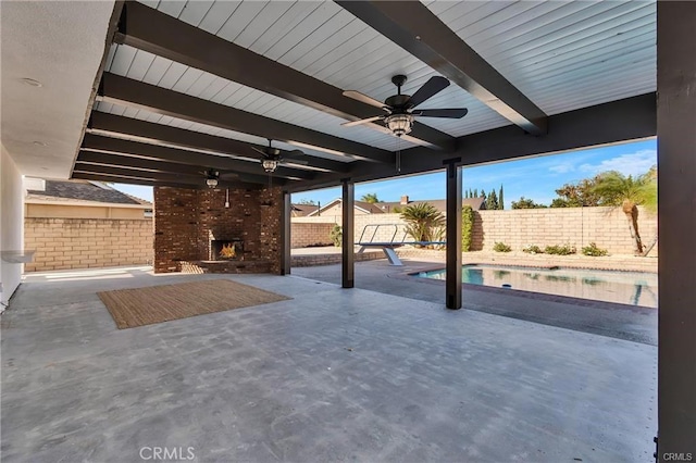 view of patio / terrace with an outdoor brick fireplace, ceiling fan, and a fenced in pool