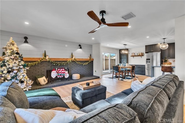 living room with light wood-type flooring and ceiling fan