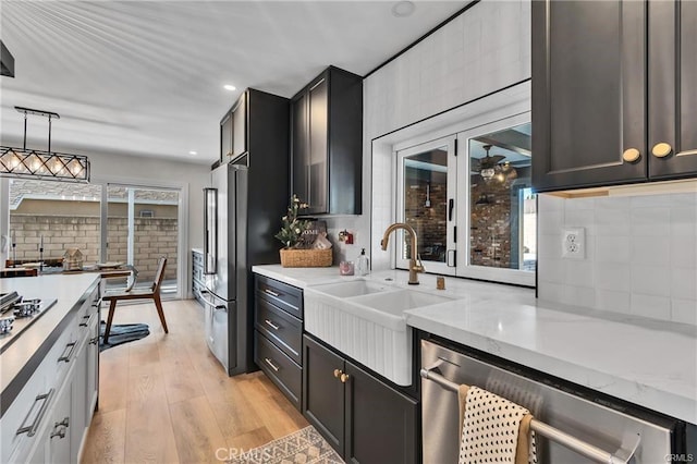 kitchen with decorative light fixtures, light hardwood / wood-style floors, plenty of natural light, and tasteful backsplash