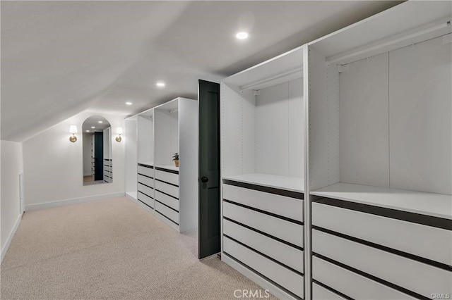 walk in closet featuring light carpet and lofted ceiling