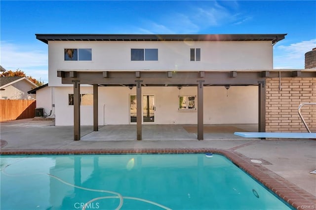 rear view of property featuring a patio, a fenced in pool, and cooling unit