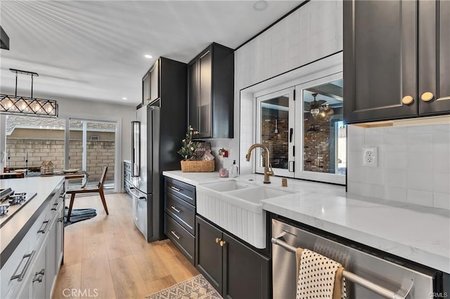 kitchen with pendant lighting, decorative backsplash, light wood-type flooring, and a wealth of natural light