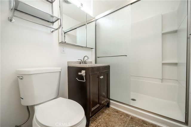 bathroom with tile patterned floors, vanity, toilet, and walk in shower