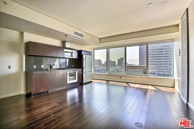 kitchen with dark hardwood / wood-style flooring, dark brown cabinetry, sink, and appliances with stainless steel finishes