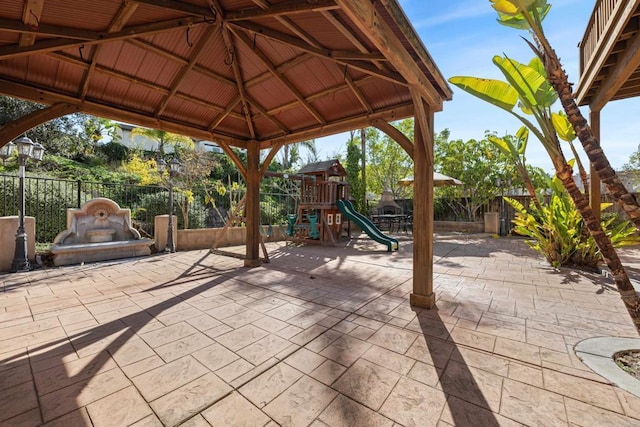 view of patio with a playground and a gazebo