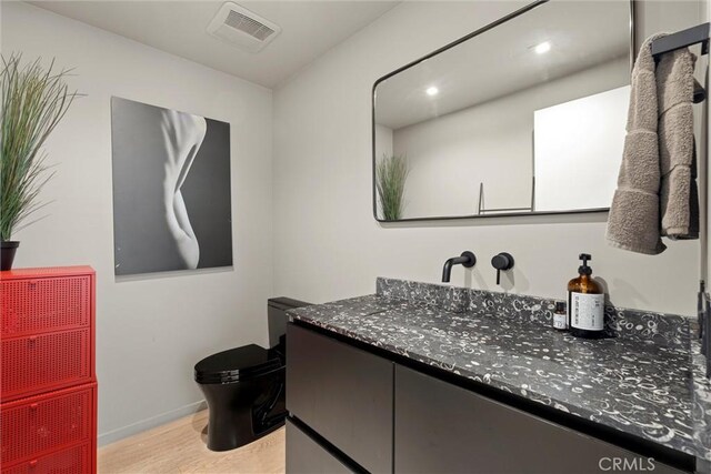 bathroom with vanity, toilet, and wood-type flooring