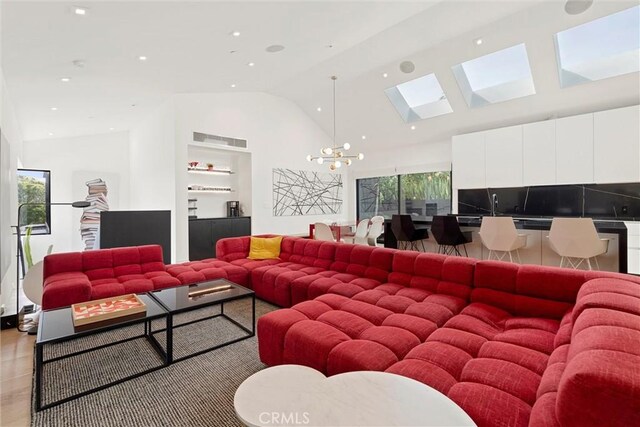 living room with light hardwood / wood-style flooring, high vaulted ceiling, and a chandelier