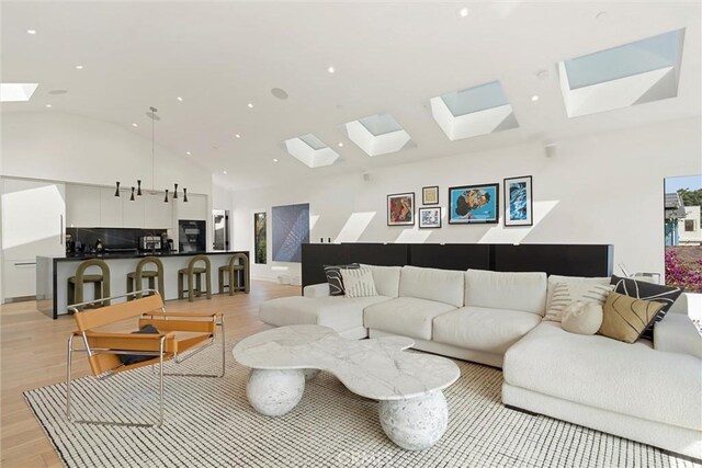 living room with vaulted ceiling with skylight and light wood-type flooring