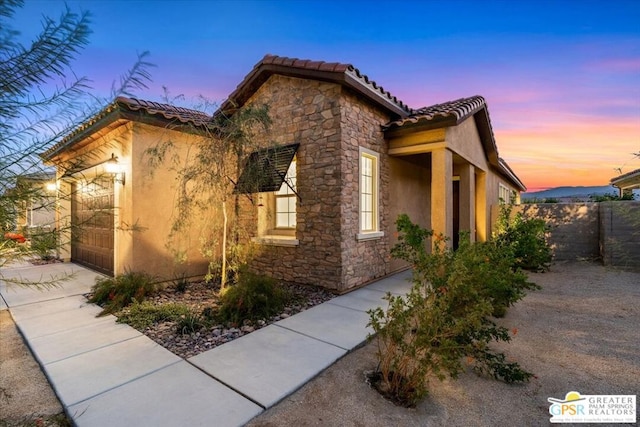 property exterior at dusk featuring a garage