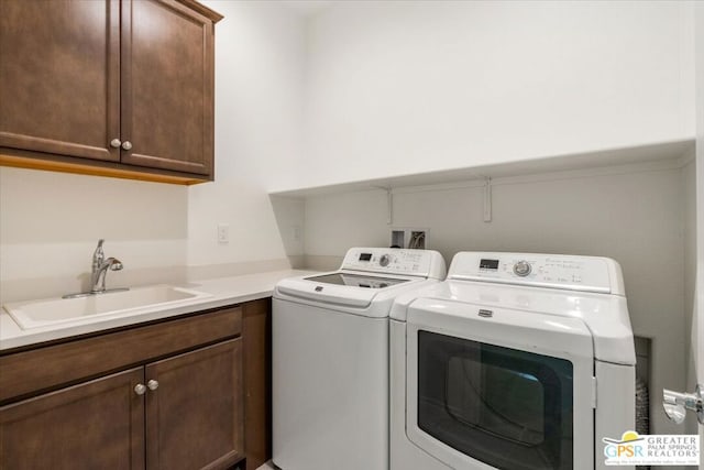 laundry room with cabinets, separate washer and dryer, and sink