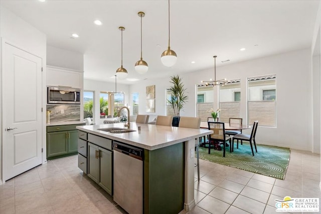 kitchen with pendant lighting, a breakfast bar, sink, an island with sink, and stainless steel appliances