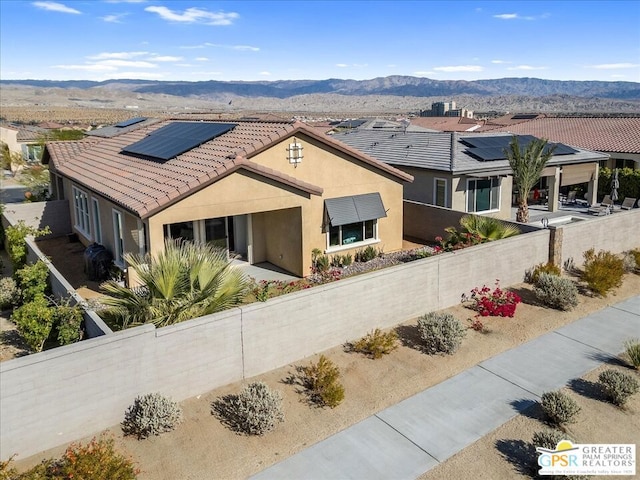 view of front of house with a mountain view and solar panels