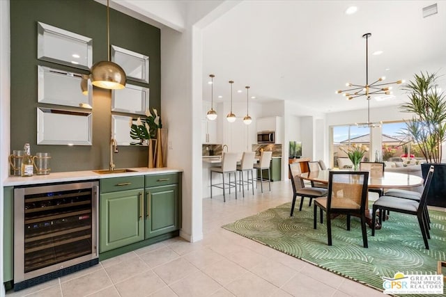 bar featuring sink, beverage cooler, a chandelier, pendant lighting, and light tile patterned floors