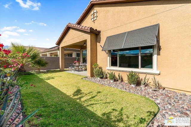 back of property featuring a yard and a patio