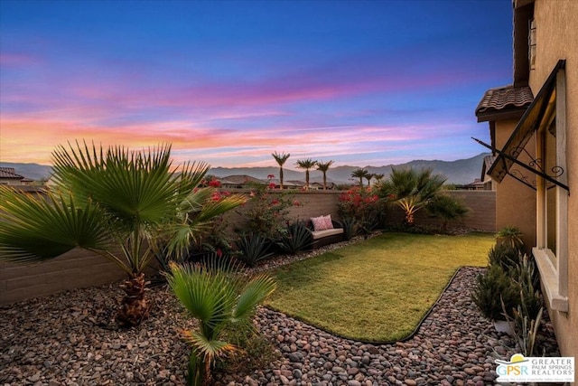 yard at dusk featuring a mountain view