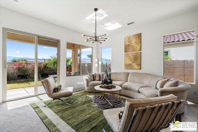 carpeted living room with a wealth of natural light and a chandelier