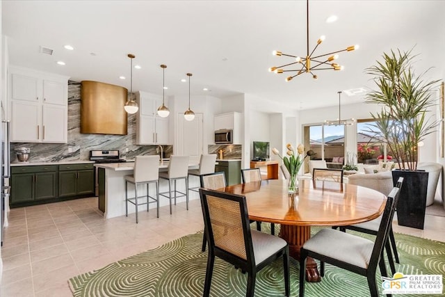 tiled dining space featuring an inviting chandelier and sink