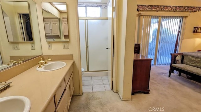 bathroom featuring plenty of natural light, a shower with shower door, and vanity