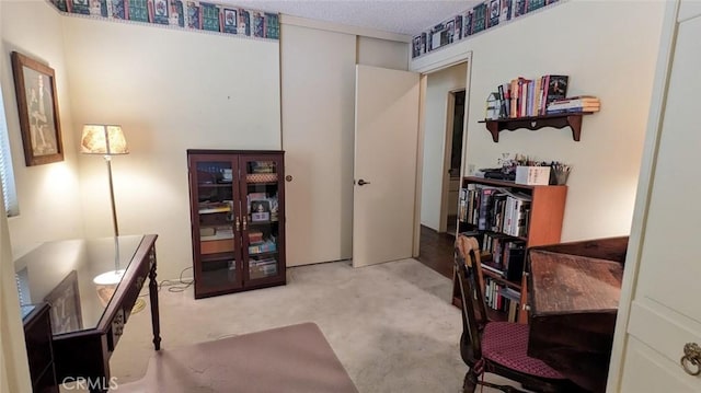 carpeted home office featuring a textured ceiling