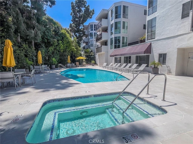 view of pool with a patio area and a hot tub