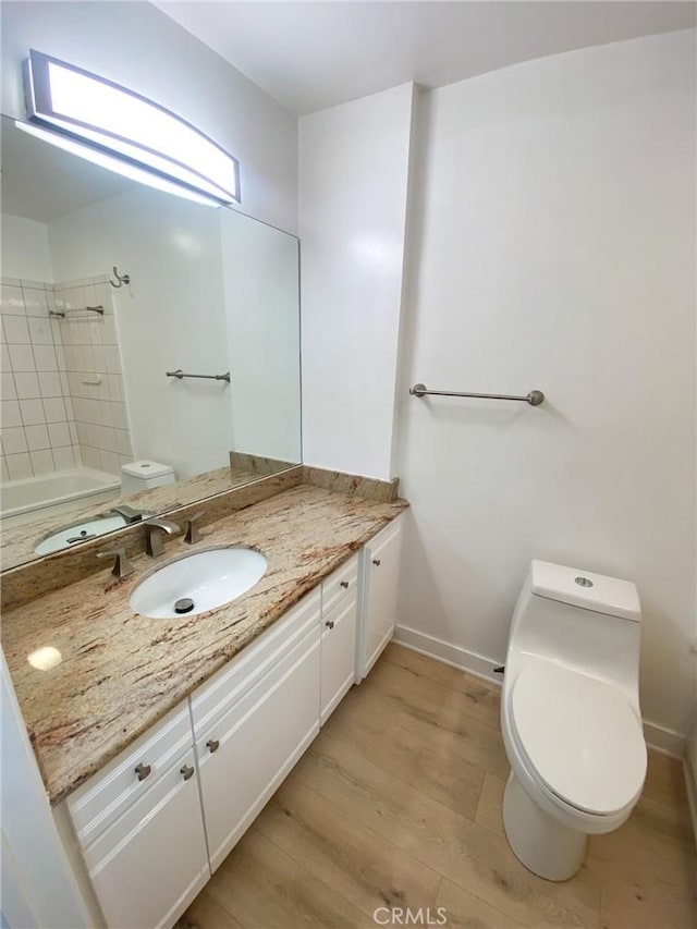 bathroom with hardwood / wood-style floors, vanity, and toilet