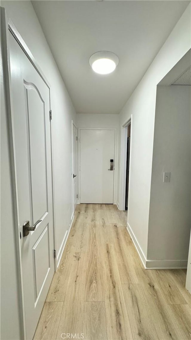 corridor with light hardwood / wood-style floors