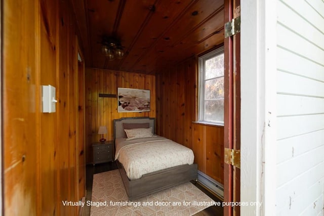 bedroom featuring a baseboard radiator, hardwood / wood-style flooring, wooden ceiling, and wood walls