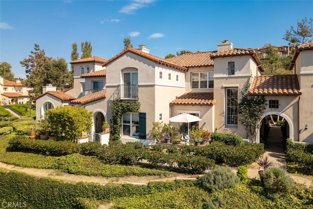 mediterranean / spanish house featuring a balcony