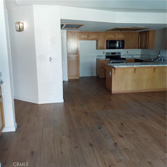 kitchen with a kitchen bar, sink, stainless steel range with electric cooktop, dark hardwood / wood-style floors, and kitchen peninsula