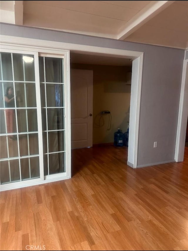 interior space with beam ceiling and light hardwood / wood-style floors