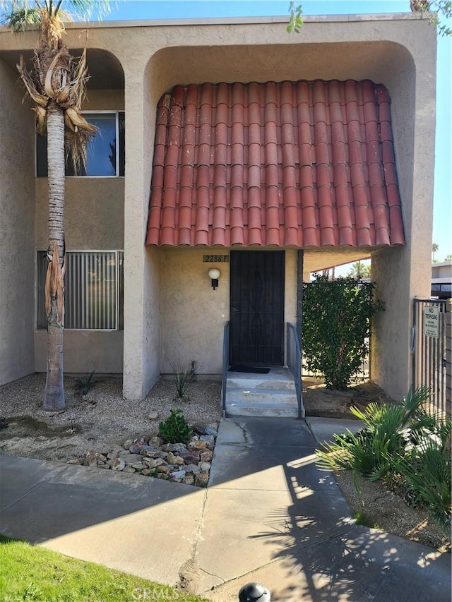 property entrance featuring stucco siding and a tiled roof