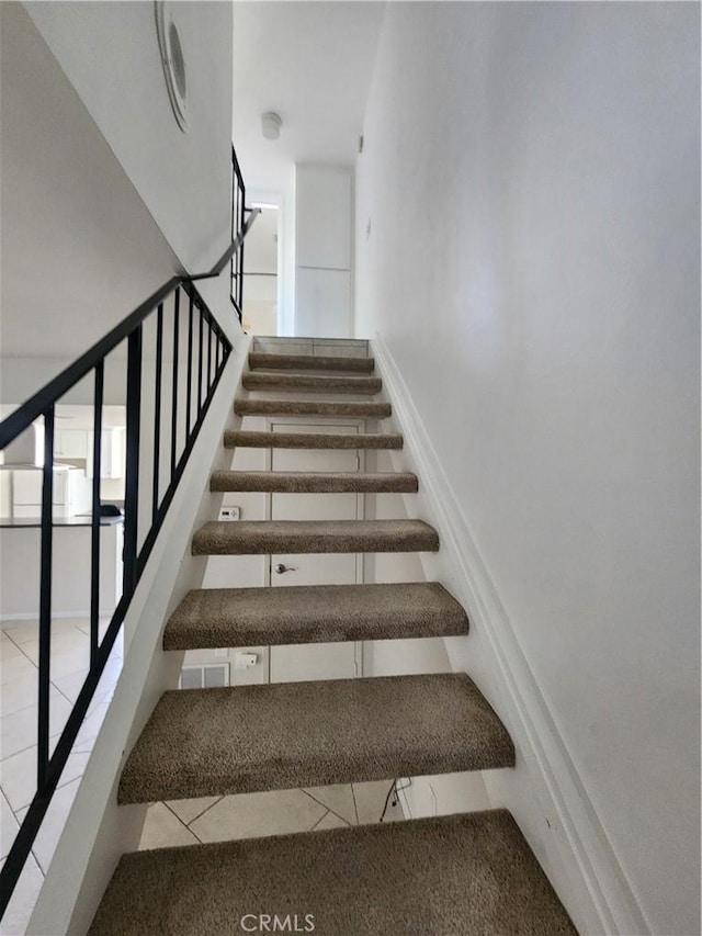 stairway with tile patterned floors