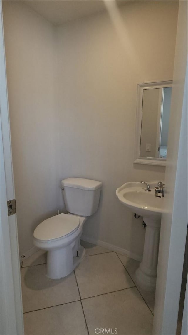 bathroom with toilet and tile patterned flooring