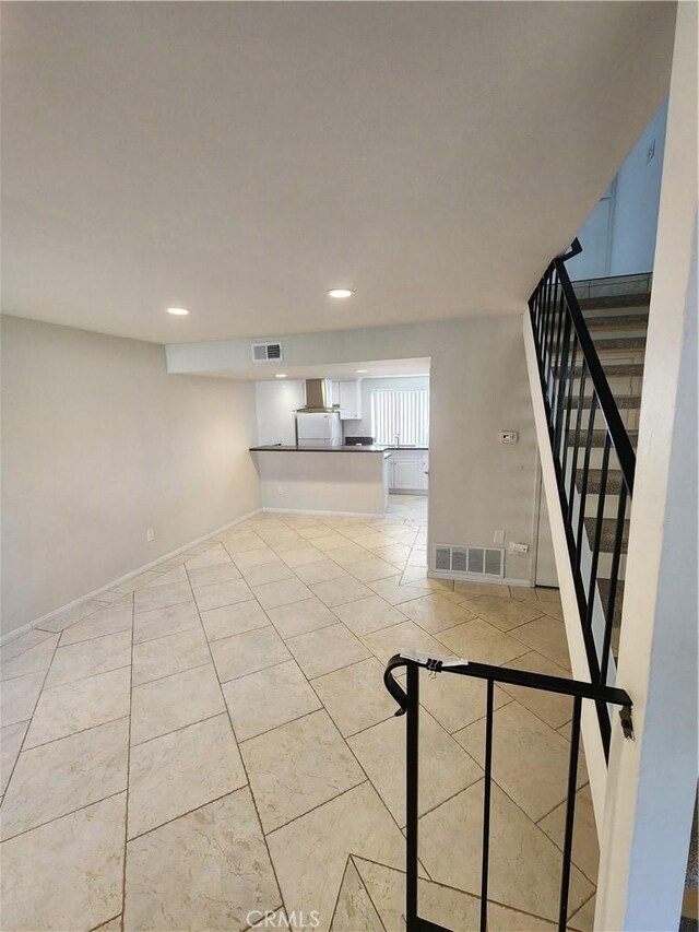 interior space with stairway, light tile patterned floors, and visible vents