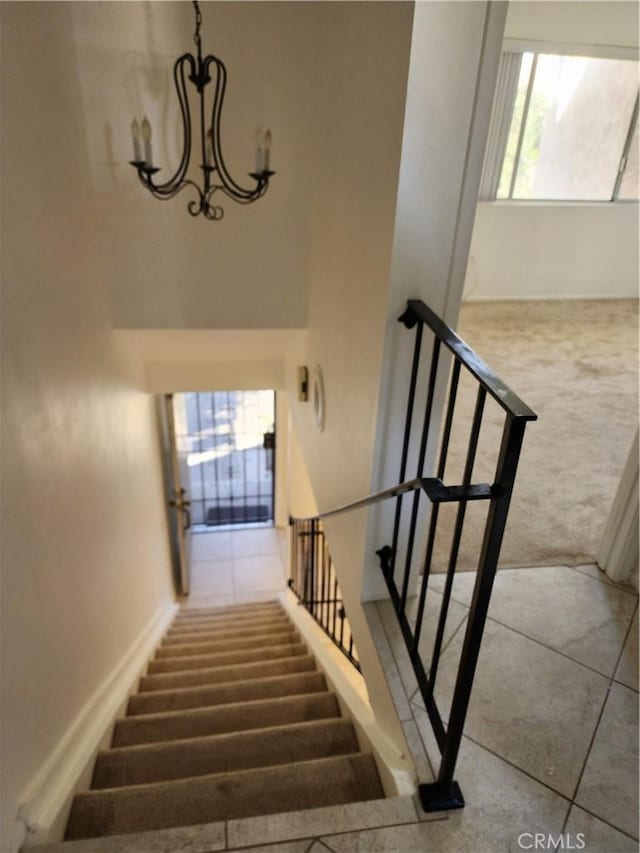 stairs with a chandelier and carpet