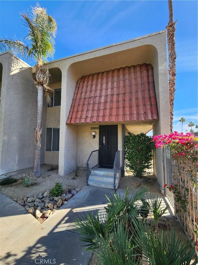 view of front facade with stucco siding and a tile roof