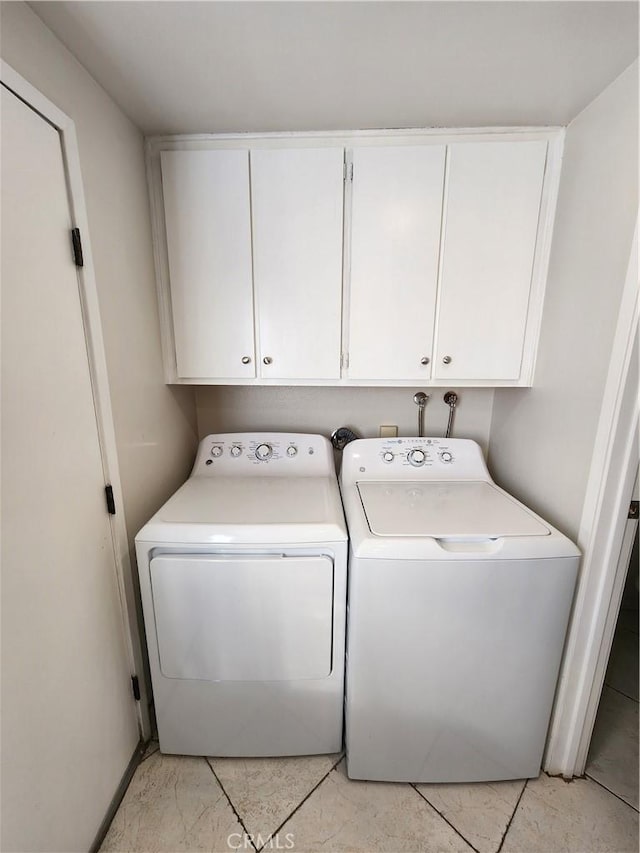 washroom featuring cabinet space and independent washer and dryer