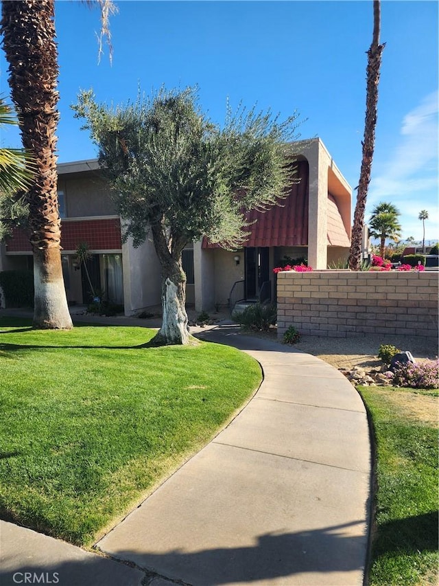 view of front facade with stucco siding and a front yard