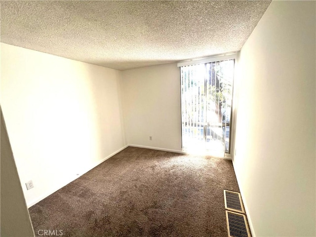 unfurnished room featuring carpet and a textured ceiling